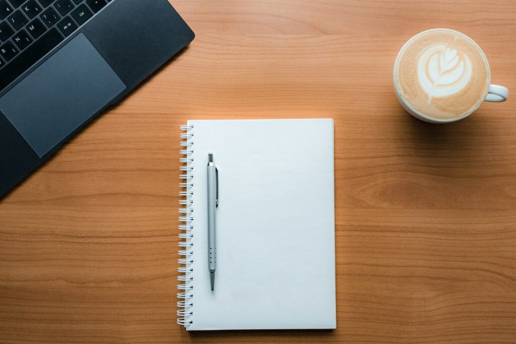 Blank notebook, pen and coffee on a desk, ready to plan midlife income priorities